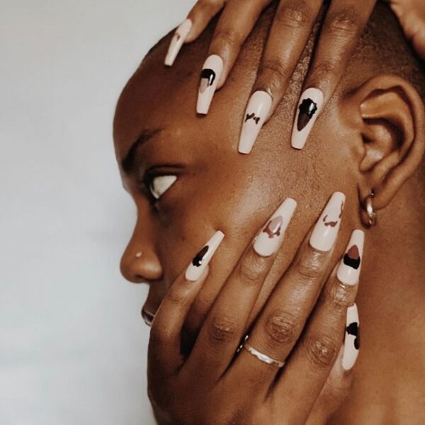 Woman wearing graphic white acrylic nails