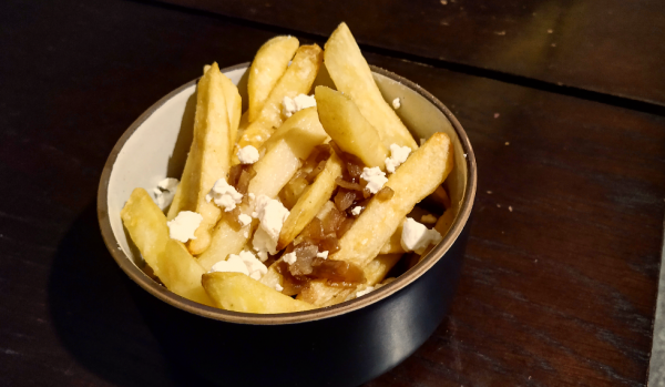 chips in a bowl with onion gravy and goats cheese on top