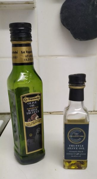 one larger bottle of La Espagnola truffle oil next to a smaller bottle of M and S truffle oil