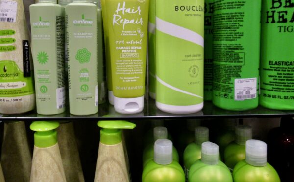 Image of green bottles of hair products on shop shelf
