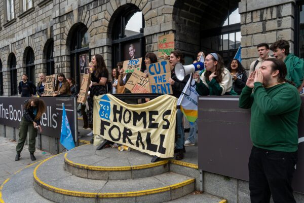 A group of protestors hold a banner reading 'HOMES FOR ALL' in front of the Book of Kells exhibit in Trinity College, Dublin, Ireland. 