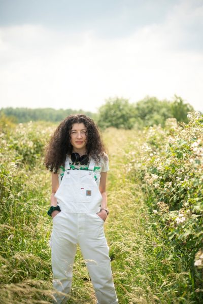 striking white dungarees and green floral background