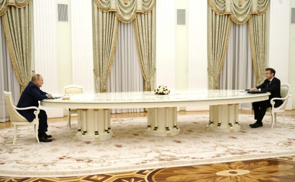 Putin and Macron meeting with a large table