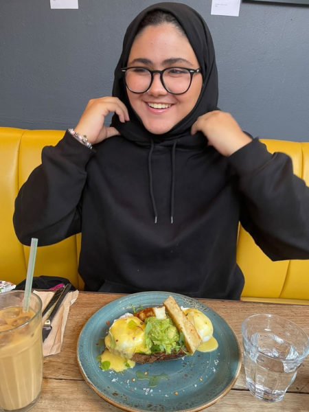 Shyema smiling with a plate of food in front of her