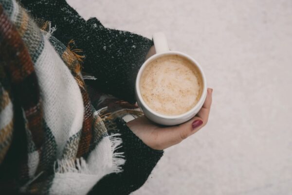 Someone holding a mug wearing a scarf winter aesthetic