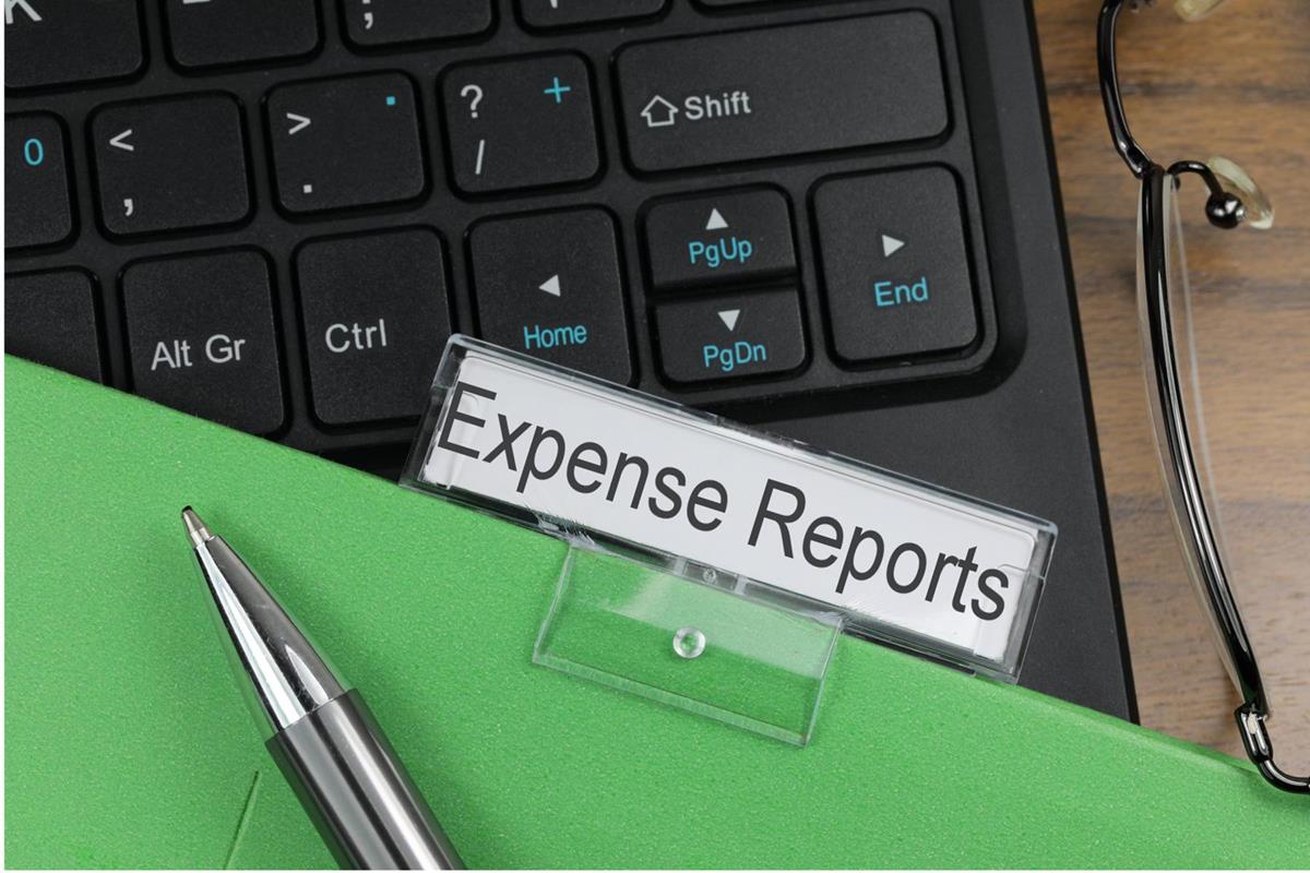 Expenses report folder lying over keyboard on desk